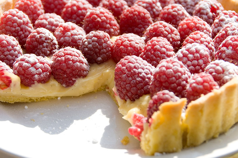 Aangesneden frambozentaart in de zon